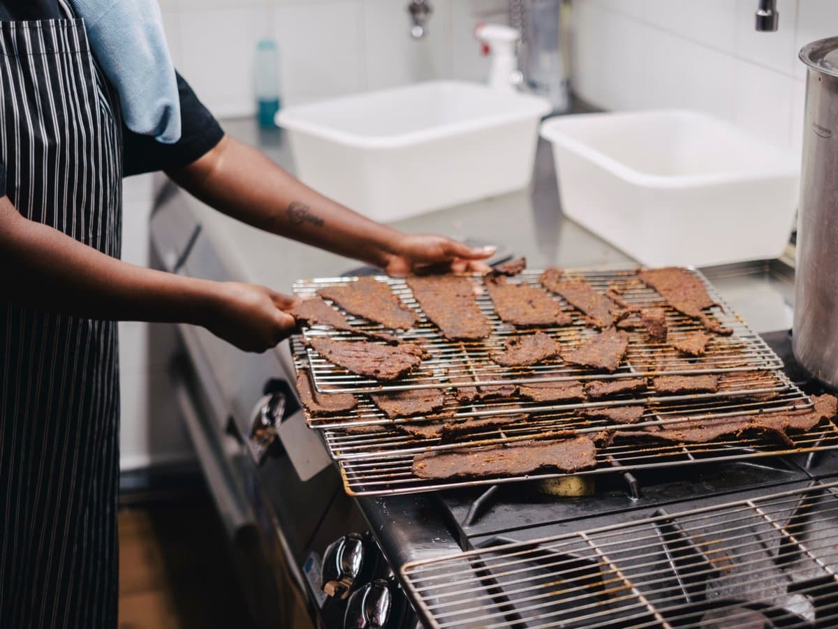 Laying kilishi by hand on the drying racks